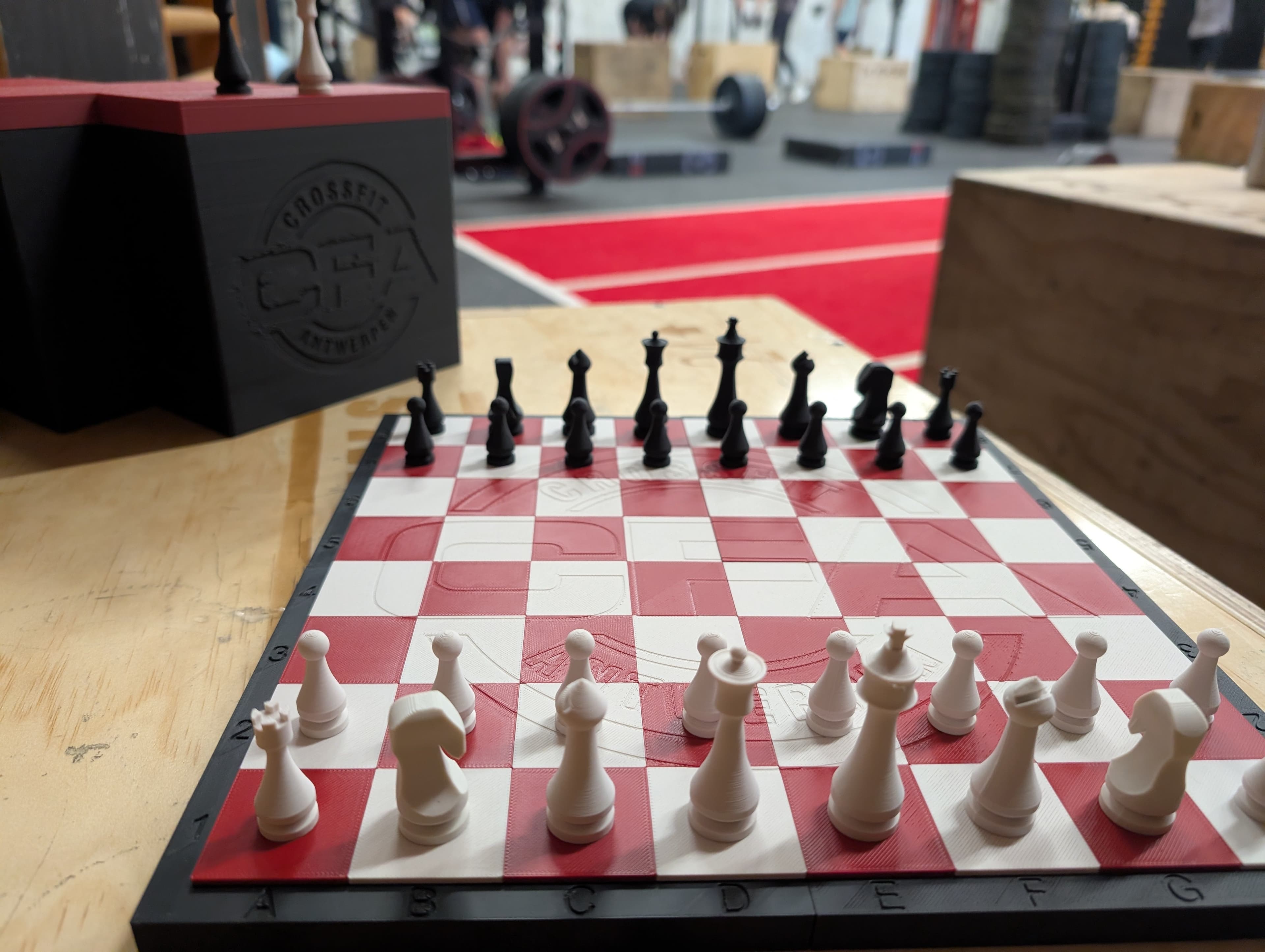 Custom red and white Crossfit Antwerpen chess set with embossed logo